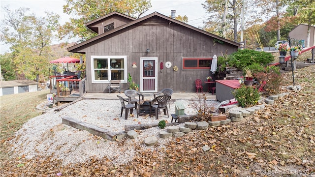 rear view of property featuring a deck and a patio area