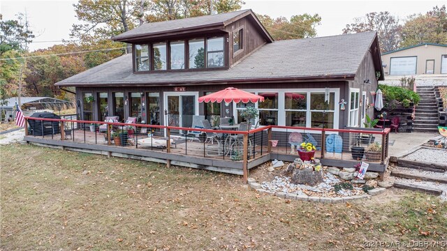 back of property with a yard and a wooden deck