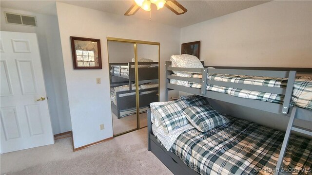 bedroom with light colored carpet, a closet, and ceiling fan