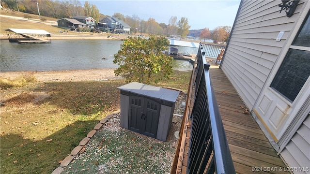 deck with a lawn and a water view