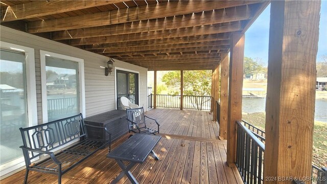 deck featuring covered porch and a water view