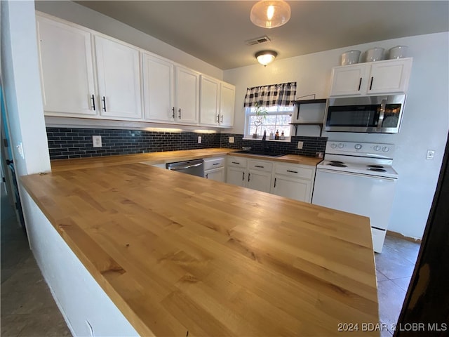 kitchen featuring stainless steel appliances, wood counters, tile patterned floors, decorative backsplash, and white cabinets