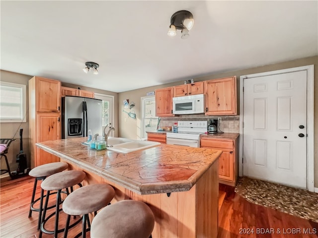 kitchen featuring white appliances, a center island, and plenty of natural light