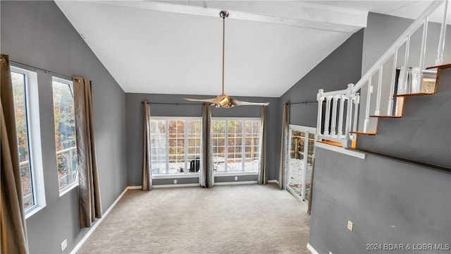 unfurnished living room with beam ceiling, a healthy amount of sunlight, light colored carpet, and ceiling fan