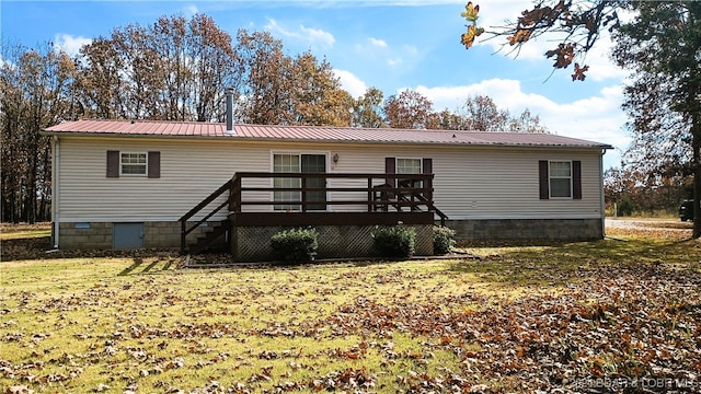 rear view of house featuring a deck and a lawn