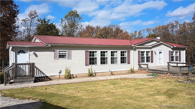 rear view of property featuring a wooden deck and a yard