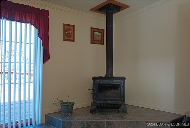 interior details with ornamental molding, a wood stove, and tile patterned floors