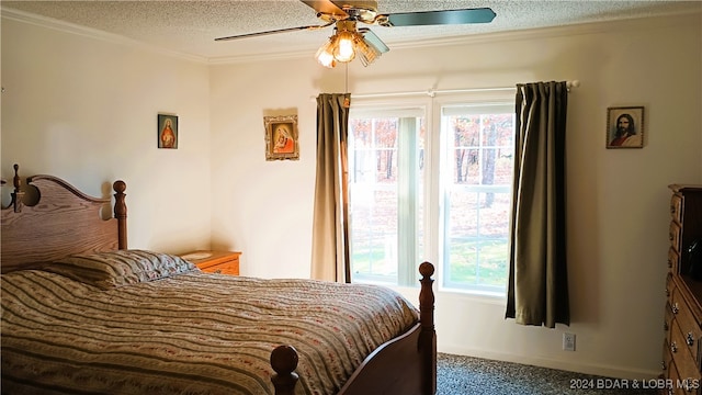 bedroom featuring ornamental molding, carpet, a textured ceiling, and ceiling fan