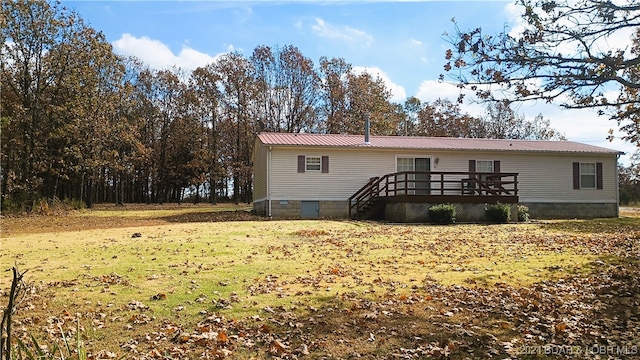 rear view of property with a deck and a lawn