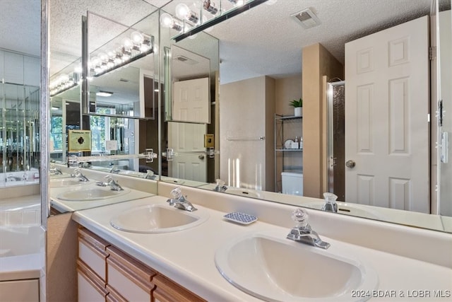 bathroom featuring vanity, a textured ceiling, and walk in shower