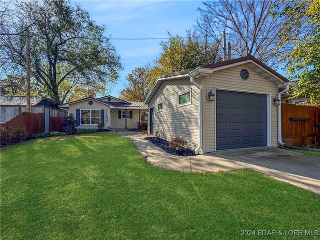 view of front of property featuring fence, concrete driveway, a front lawn, and a garage