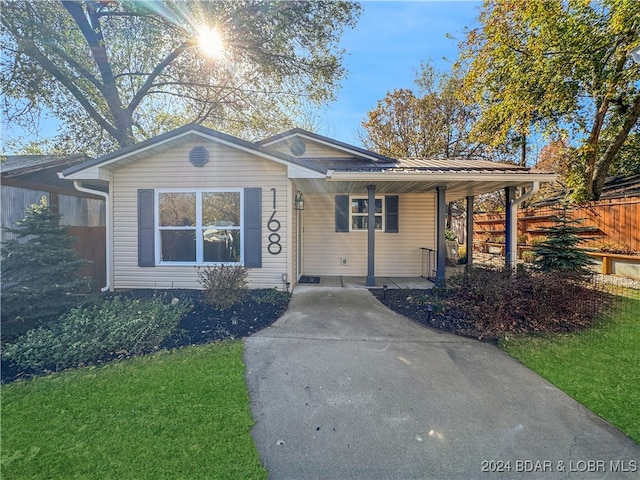 view of front of property featuring a carport and a front lawn