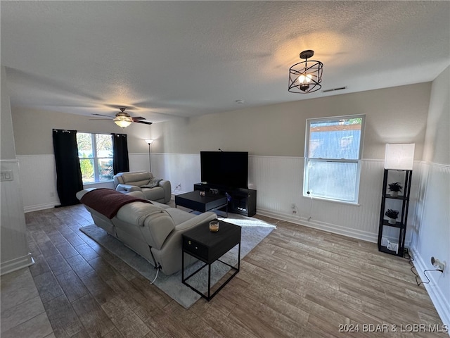 living room featuring wood-type flooring, a textured ceiling, and plenty of natural light