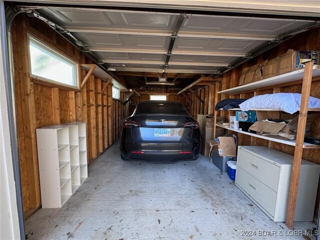 garage with wooden walls and a garage door opener