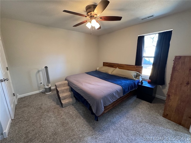 carpeted bedroom featuring a textured ceiling and ceiling fan