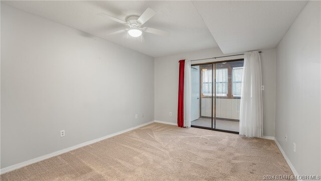 carpeted spare room featuring ceiling fan