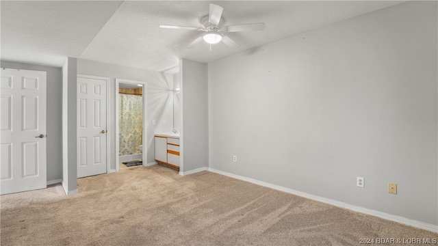 unfurnished bedroom featuring a textured ceiling, light colored carpet, and ceiling fan