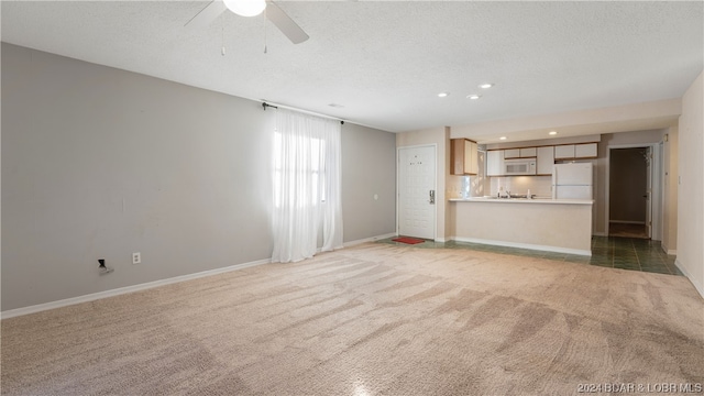 unfurnished living room with a textured ceiling, carpet floors, and ceiling fan