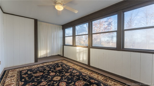 unfurnished sunroom featuring ceiling fan