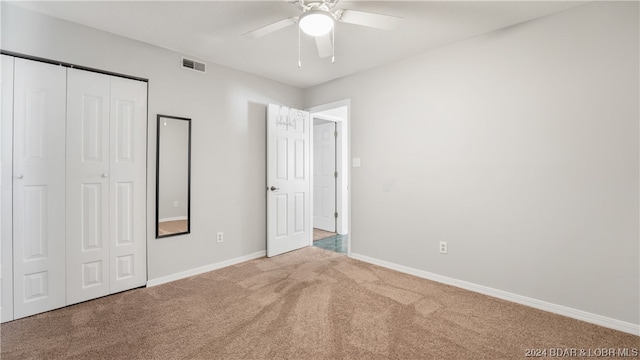 unfurnished bedroom with carpet floors, a closet, and ceiling fan