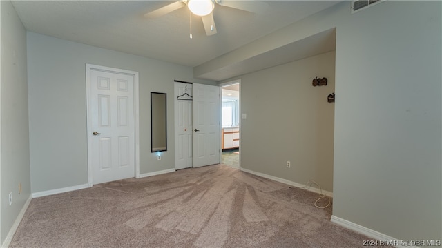 unfurnished room with light colored carpet and ceiling fan