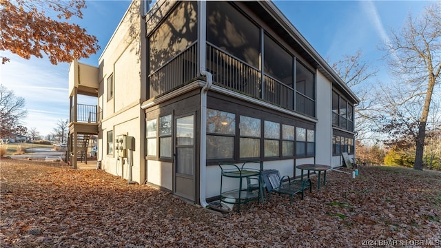 view of home's exterior with a balcony and a sunroom