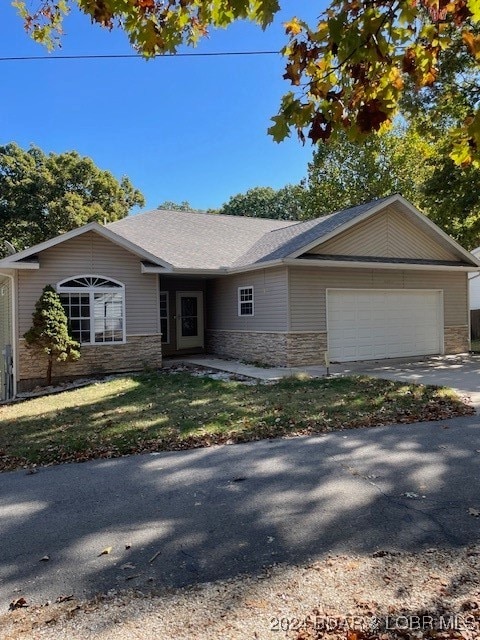 ranch-style house with a garage and a front lawn