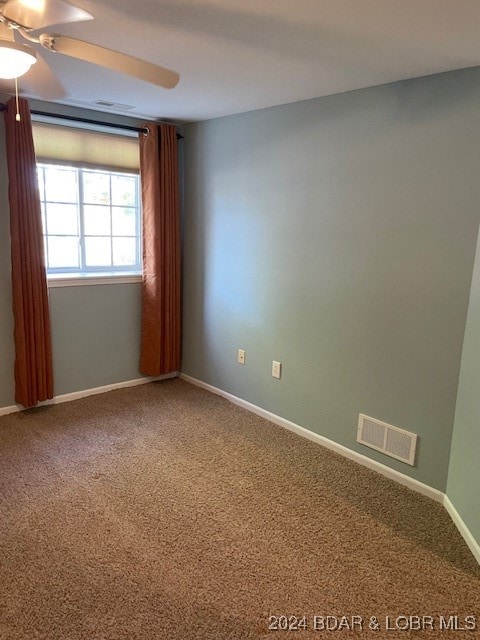 spare room featuring carpet and ceiling fan