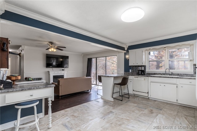 kitchen with kitchen peninsula, white cabinets, ceiling fan, ornamental molding, and dishwasher