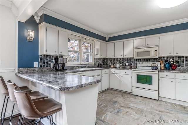 kitchen featuring white appliances, sink, kitchen peninsula, white cabinets, and ornamental molding