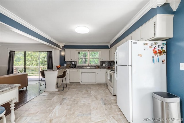 24950 State Rd A Rd, Richland, MO 65556 - kitchen featuring white appliances, ornamental molding, white cabinetry, a peninsula, and a breakfast bar area