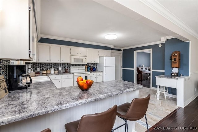 24950 State Rd A Rd, Richland, MO 65556 - kitchen with white appliances, a peninsula, wood finished floors, tasteful backsplash, and crown molding