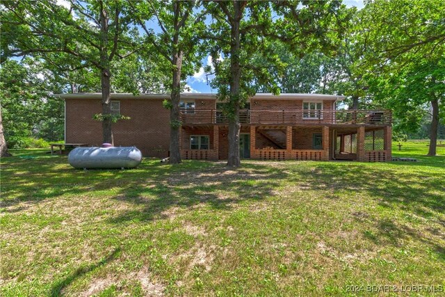 24950 State Rd A Rd, Richland, MO 65556 - rear view of property featuring brick siding, a deck, and a yard