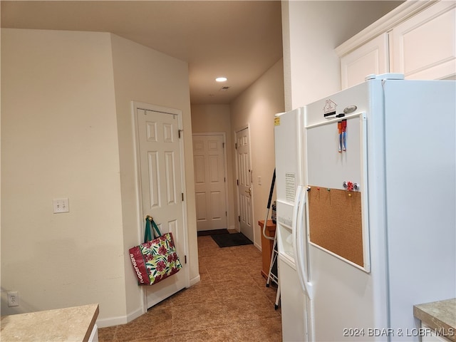 kitchen featuring white cabinets and white fridge with ice dispenser