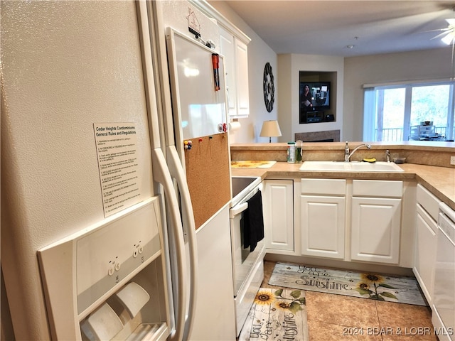 kitchen featuring white cabinetry, white appliances, sink, and light tile patterned floors