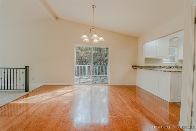 unfurnished dining area featuring vaulted ceiling with beams, light hardwood / wood-style flooring, and a notable chandelier