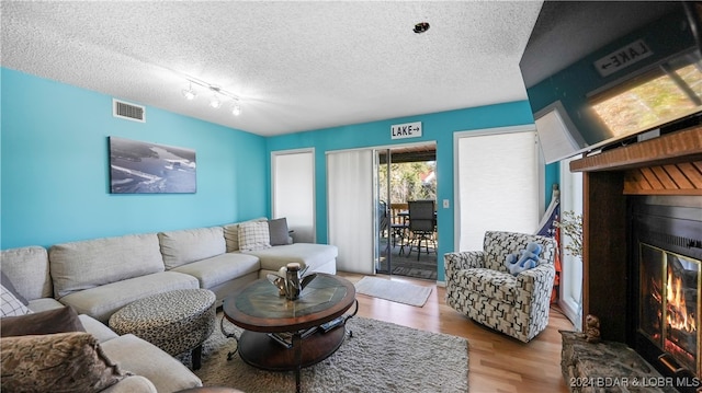 living room with a textured ceiling and light wood-type flooring