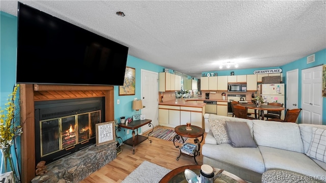 living room with light hardwood / wood-style floors and a textured ceiling