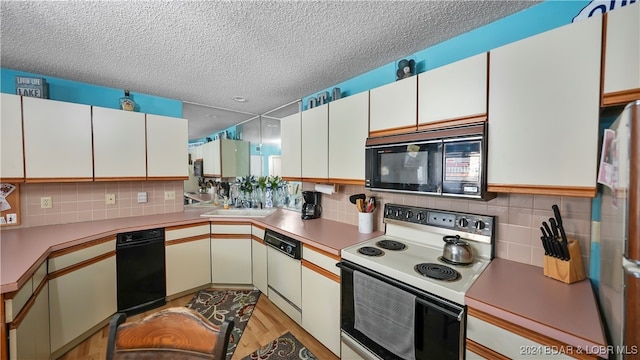 kitchen featuring light hardwood / wood-style floors, backsplash, white cabinetry, a textured ceiling, and white appliances