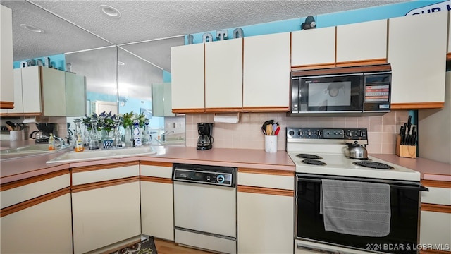 kitchen featuring decorative backsplash, white cabinets, sink, and white appliances