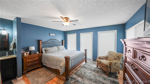 bedroom with light hardwood / wood-style floors, a textured ceiling, and ceiling fan