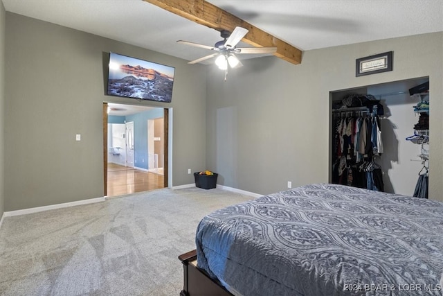 bedroom featuring a closet, ensuite bath, carpet flooring, beam ceiling, and ceiling fan