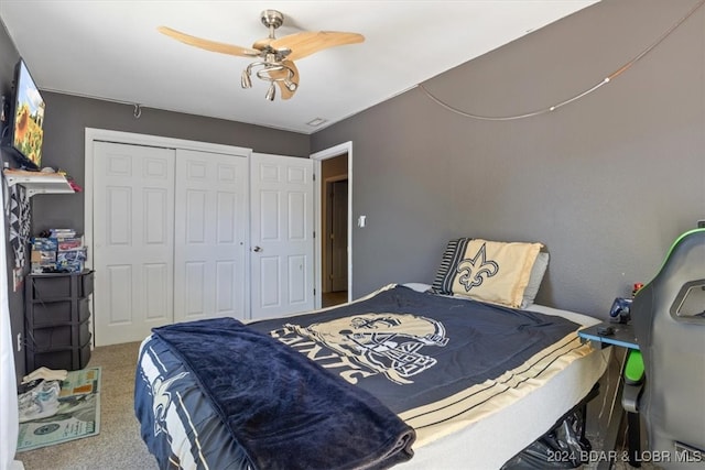 carpeted bedroom with ceiling fan and a closet