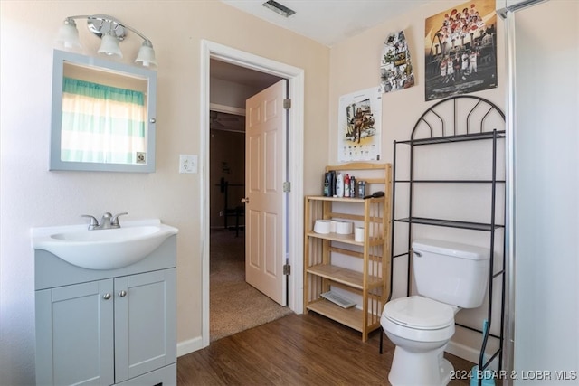 bathroom featuring vanity, hardwood / wood-style flooring, and toilet