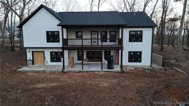 back of property featuring a garage and a patio area