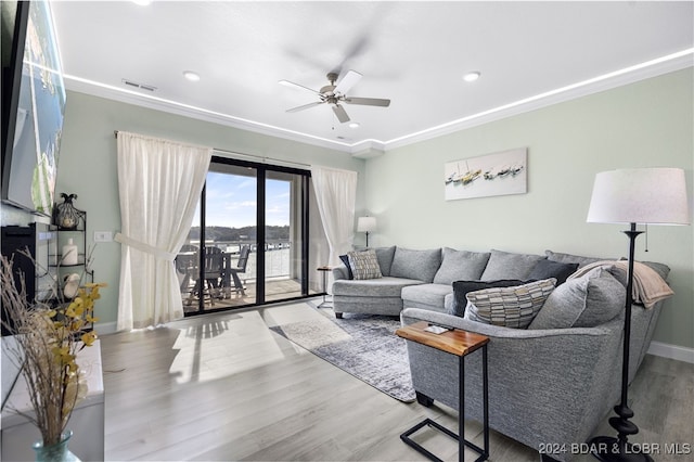 living room with ornamental molding, light hardwood / wood-style flooring, and ceiling fan