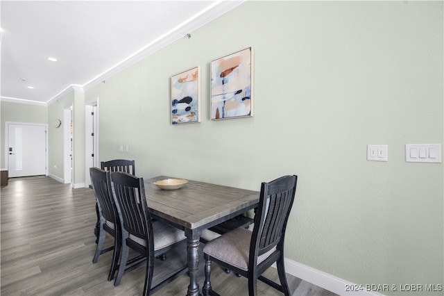 dining space featuring ornamental molding and dark hardwood / wood-style floors