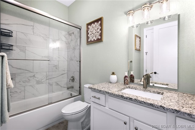 full bathroom with toilet, vanity, and shower / bath combination with glass door