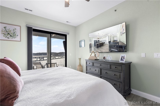 bedroom featuring access to exterior, dark hardwood / wood-style floors, and ceiling fan