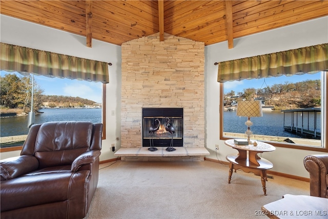 sitting room featuring carpet, vaulted ceiling with beams, a fireplace, a water view, and wooden ceiling